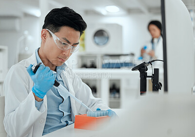 Buy stock photo Shot of a young man filling a test tube samples