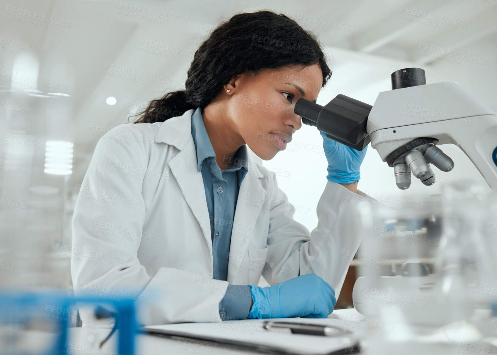 Buy stock photo Black woman, microscope and research in lab for science, investigation and experiment results. Scientist, tech and study at table for medicine engineering, pharmaceutical development and healthcare