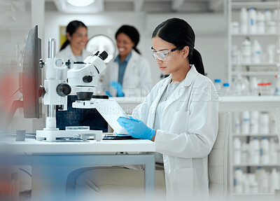 Buy stock photo Shot of a young scientist using a digital tablet at work