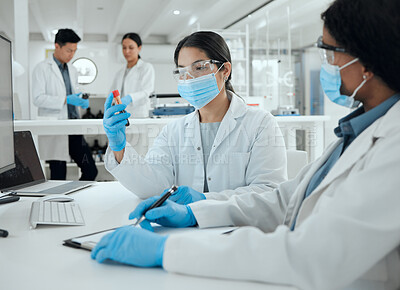Buy stock photo Shot of two scientists reviewing a sample together