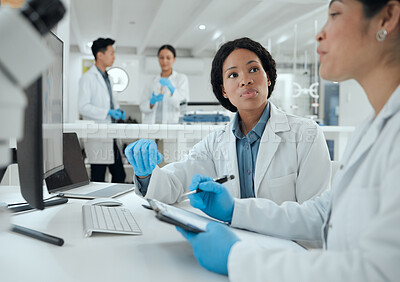 Buy stock photo Shot of two scientists helping one another in the lab