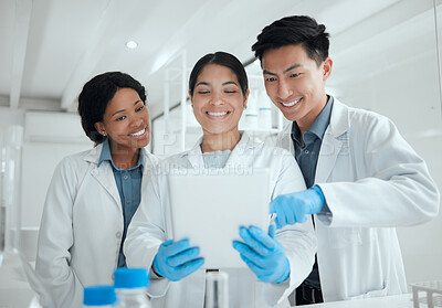 Buy stock photo Shot of a young group of scientists using a digital tablet together