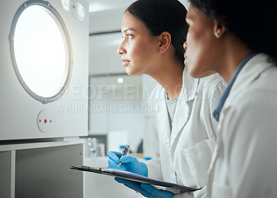 Buy stock photo Shot of two female scientists looking through a door waiting for results
