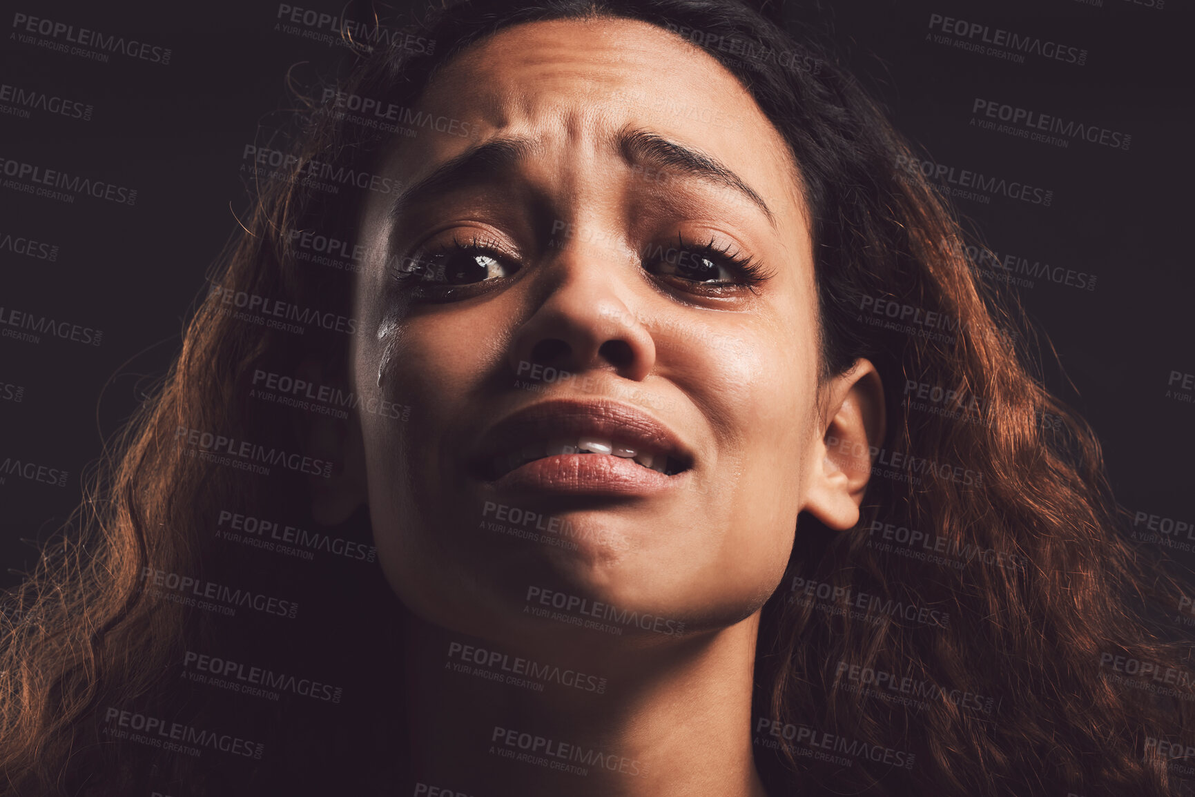 Buy stock photo Scared woman, portrait and crying with trauma for abuse, anxiety or mental illness on a dark studio background. Sad, female person or nervous victim with feeling, emotion or afraid in isolation