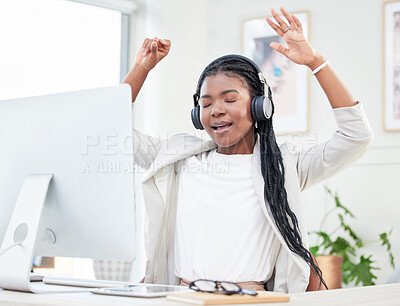 Buy stock photo Shot of a young businesswoman enjoying music while sitting at her desk