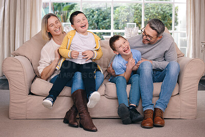 Buy stock photo Shot of a young family happily bonding together on the sofa at home