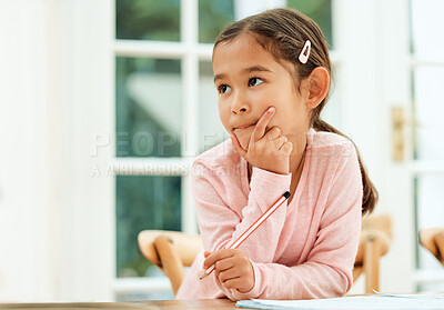 Buy stock photo Cropped shot of an adorable little girl looking thoughtful while doing her homework
