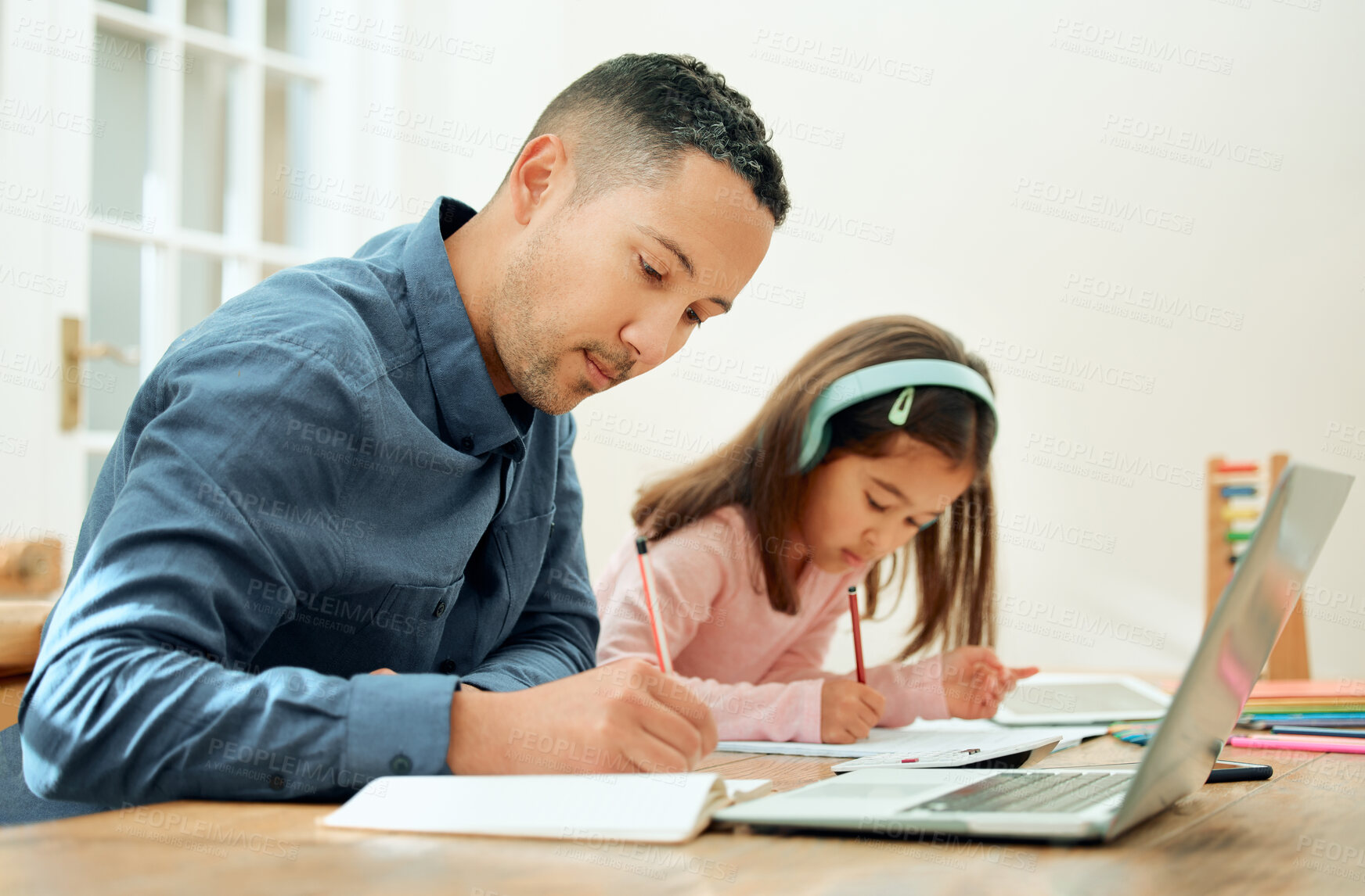 Buy stock photo Cropped shot of an adorable little girl doing her homework next to her dad