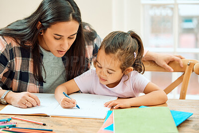 Buy stock photo Cropped shot of an adorable little girl doing her homework with some help from her mom