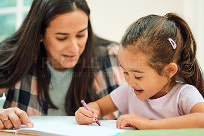 Buy stock photo Cropped shot of an adorable little girl doing her homework with some help from her mom