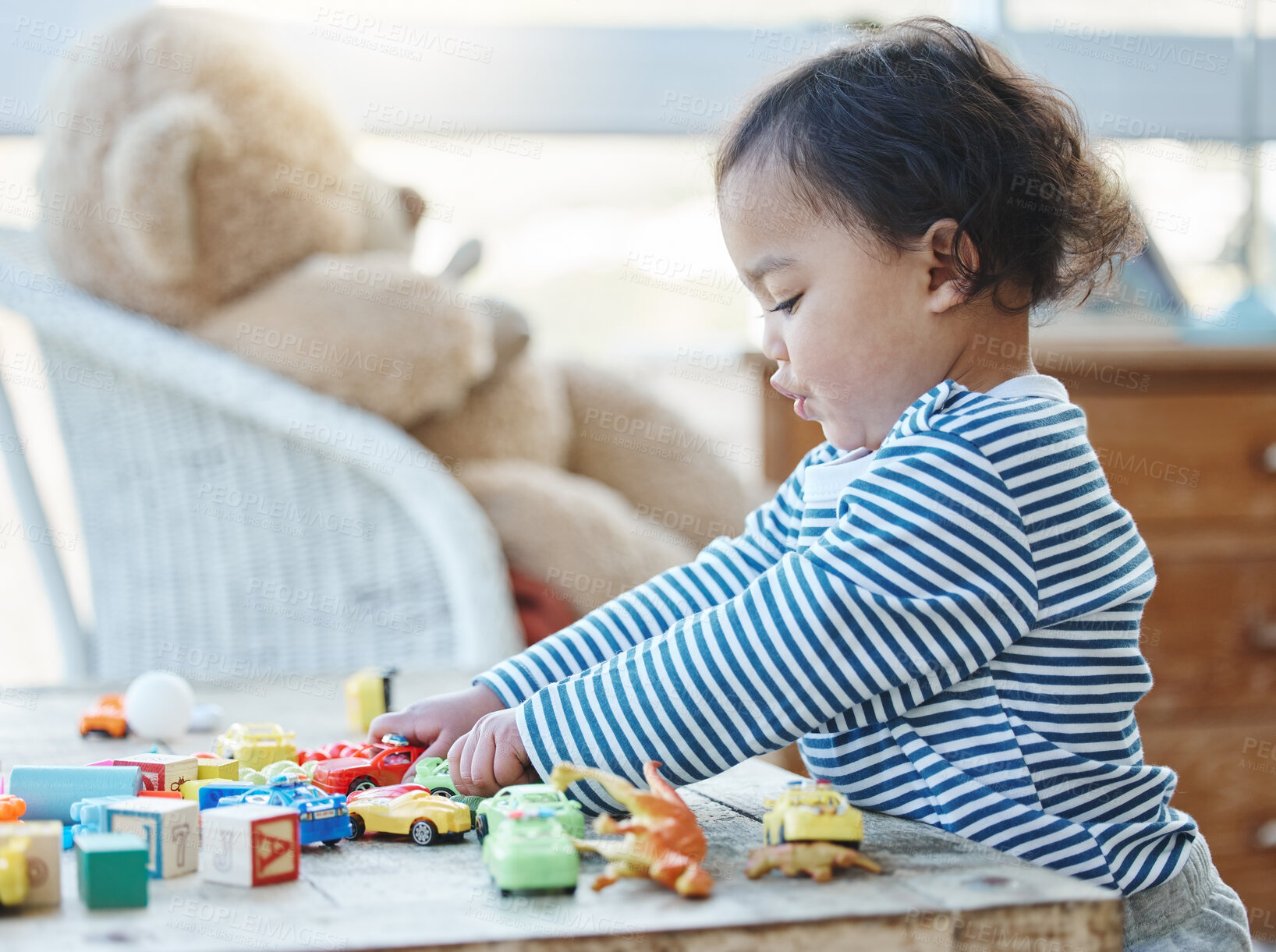 Buy stock photo Shot of an adorable little girl playing with her toys at home