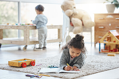 Buy stock photo Shot of an adorable little girl lying on a rug while writing