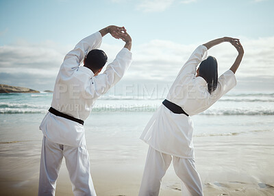 Buy stock photo Rearview shot of two unrecognizable martial artists practicing karate on the beach