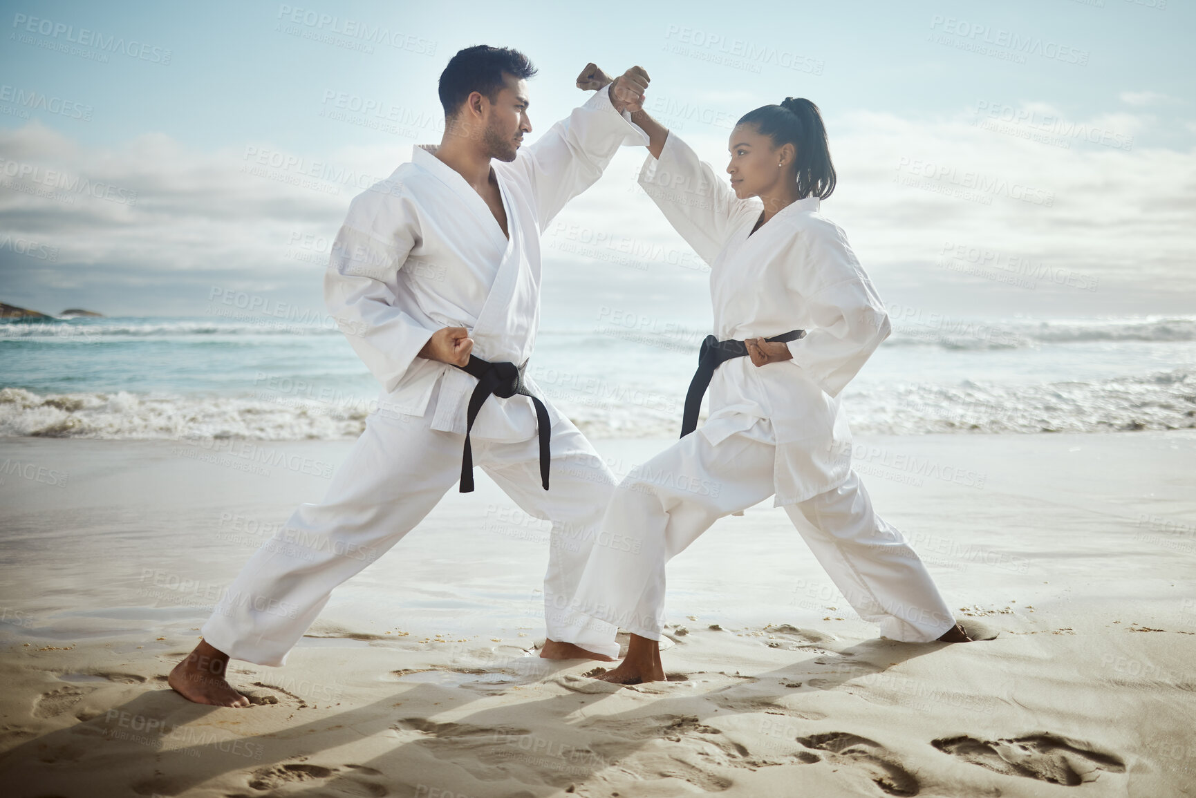 Buy stock photo Fight, karate and team at beach for training, taekwondo or performance outdoor with student. Ocean, martial arts and people practice for fitness, exercise or capoeira with warrior or master at lesson