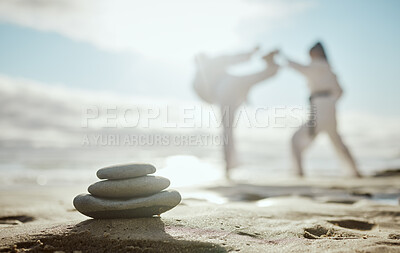 Buy stock photo Full length shot of two unrecognizable martial artists practicing karate on the beach