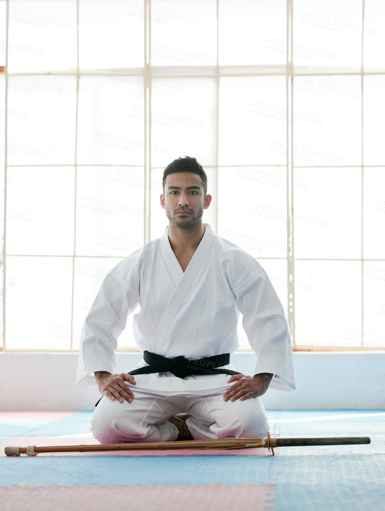 Buy stock photo Full length portrait of a handsome young martial artist practicing bojutsu in his dojo