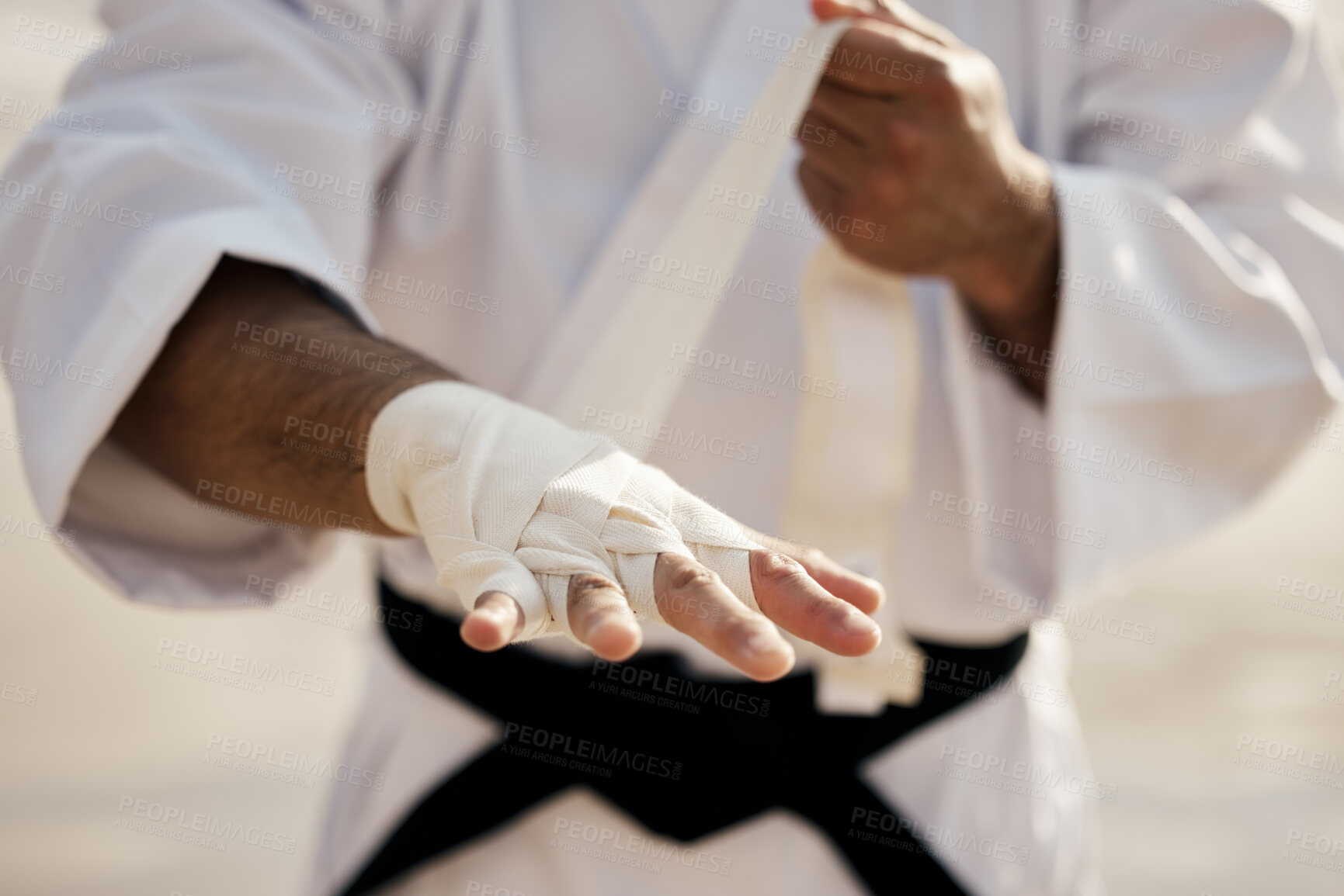 Buy stock photo Hands, warrior and bandage wrapping fist for martial arts, training or exercise to prepare for karate match. Man tying gloves, fighter and getting ready for tournament, practice or beach workout