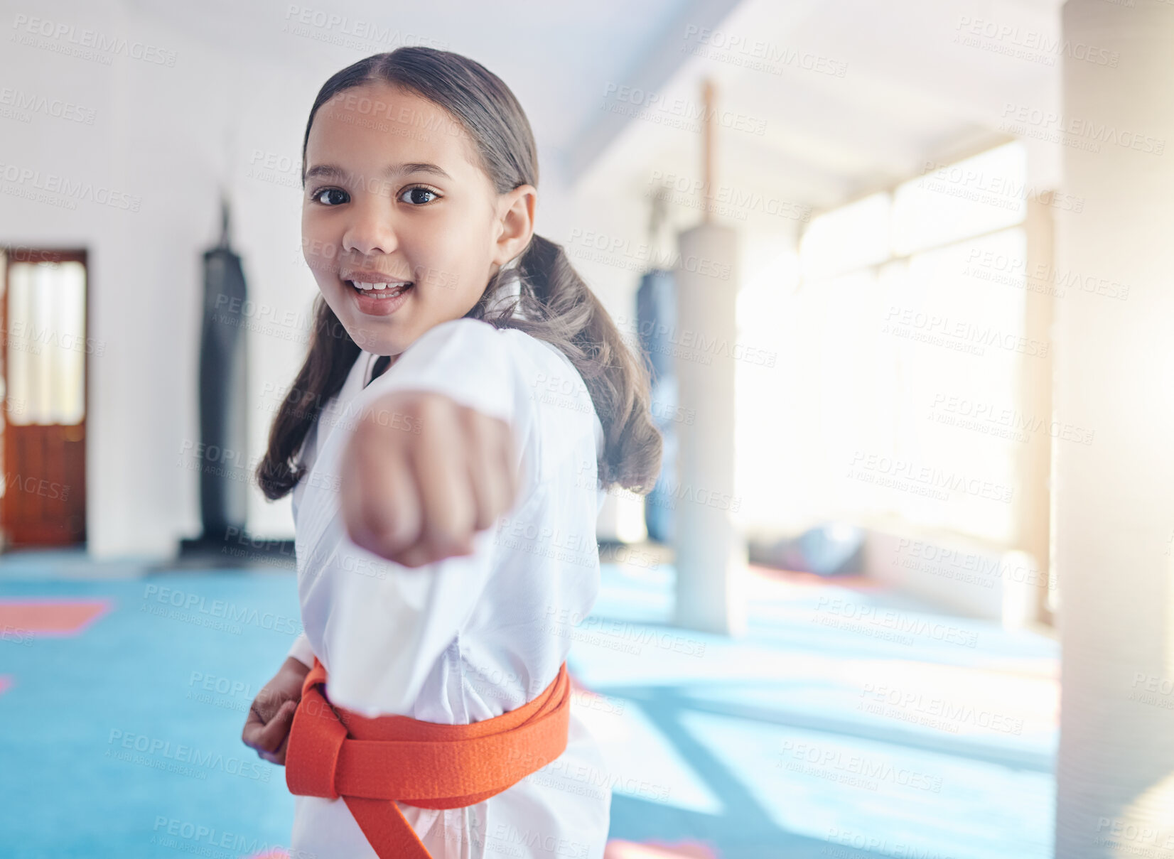 Buy stock photo Martial arts, fist and girl in studio for fitness, training and fight with orange belt, development and energy. Student, kung fu and practice in dojo as workout for self defense, karate and taekwondo