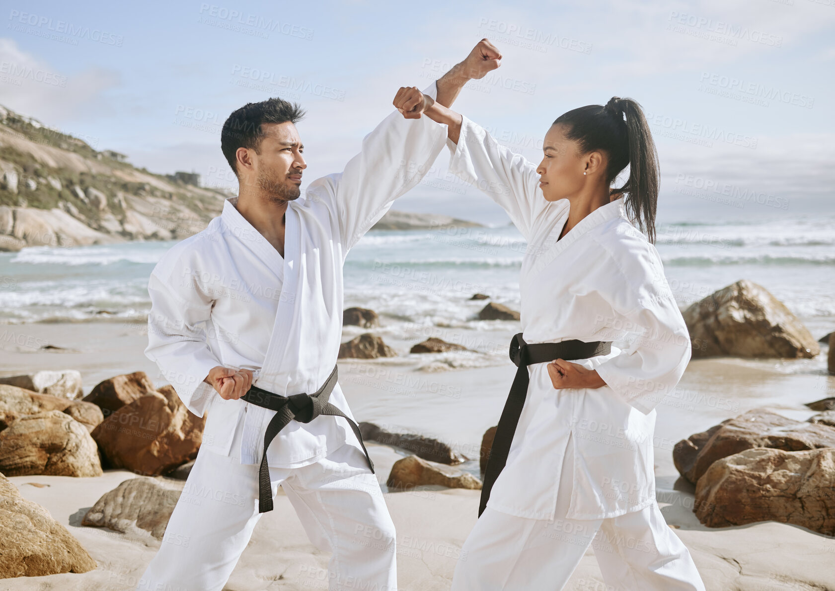 Buy stock photo Karate, martial arts and people on beach for fight, practice and learning aikido, taekwondo and jiujitsu. Sports, nature and man and woman by ocean for fitness, exercise and training for tai chi