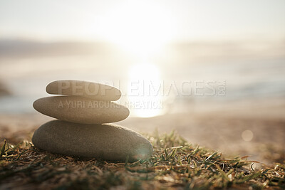 Buy stock photo Nature, calm and rocks on the beach grass for peace, balance and zen at sunset. Ocean, relaxing and a stone stack by the sea for harmony, tranquility and mindfulness in an spiritual environment