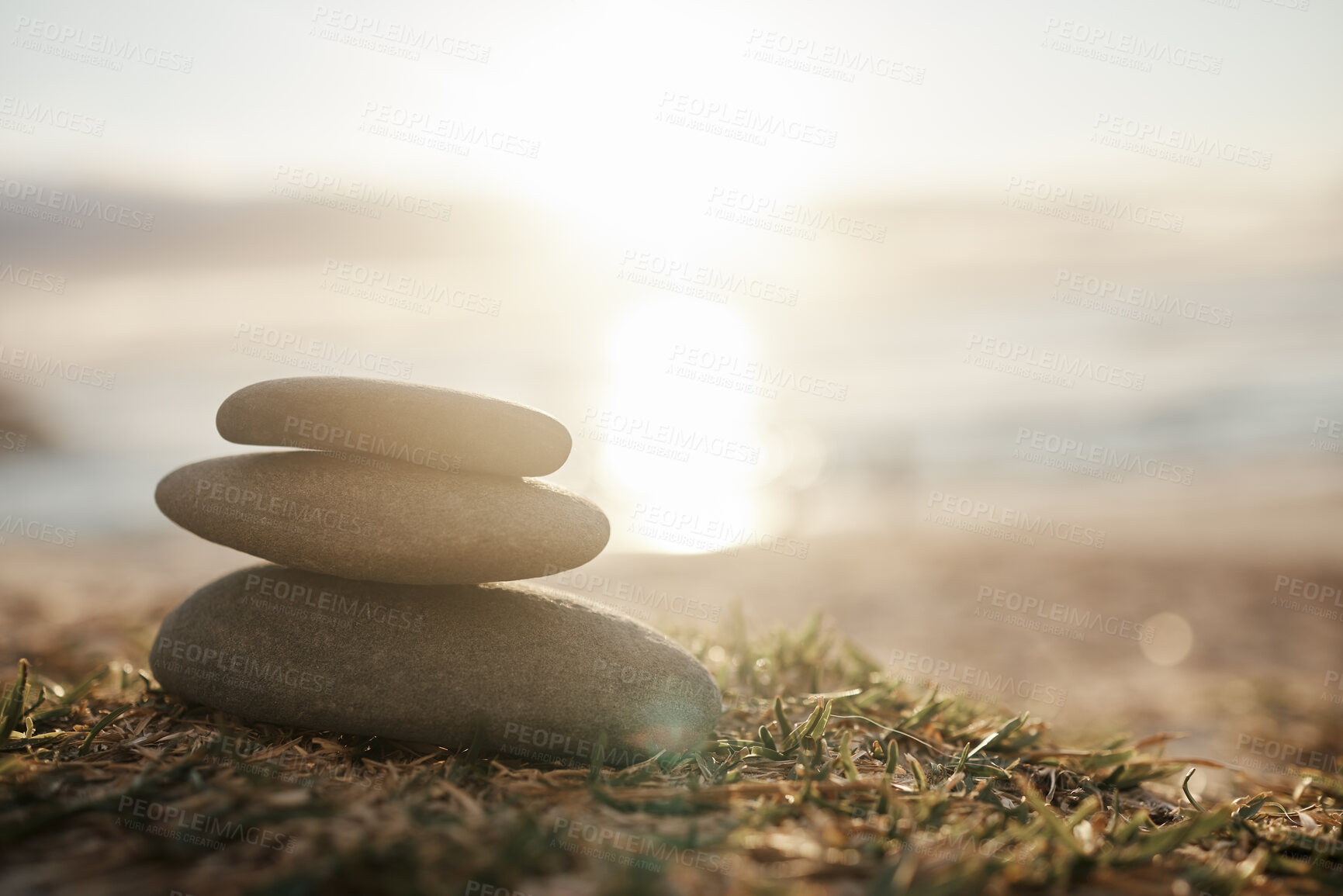 Buy stock photo Nature, calm and rocks on the beach grass for peace, balance and zen at sunset. Ocean, relaxing and a stone stack by the sea for harmony, tranquility and mindfulness in an spiritual environment