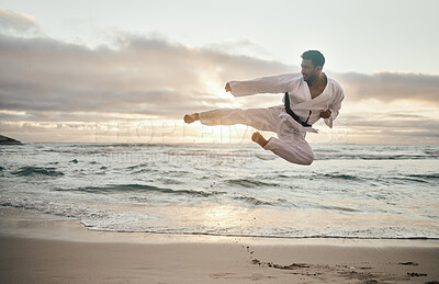 Buy stock photo Shot of a young martial artist practising karate on the beach