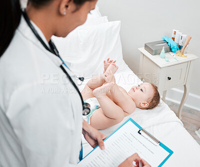 Buy stock photo Shot of a paediatrician completing paperwork during a checkup