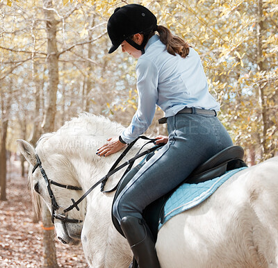 Buy stock photo Shot of an attractive young woman riding with her horse outside