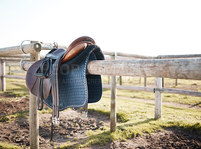 Buy stock photo Saddle, countryside and farm on ranch fence, riding and equestrian sports in nature or park. Background, agriculture or field in Texas, USA with leather seat or equipment for outdoor hobby in paddock