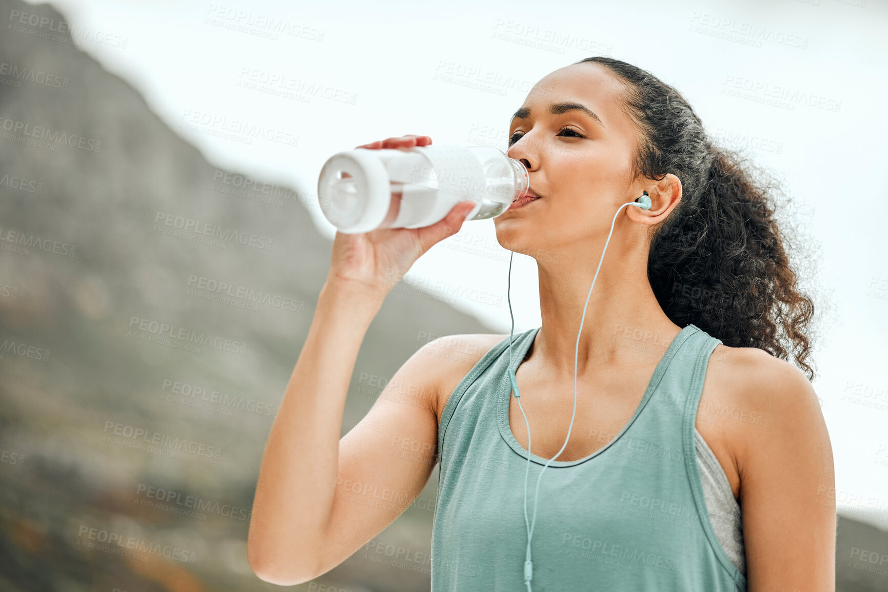 Buy stock photo Break, fitness and a woman with water in nature and music for exercise, cardio and rest from running. Sports, streaming audio and a young athlete with a bottle for a drink after training at a park