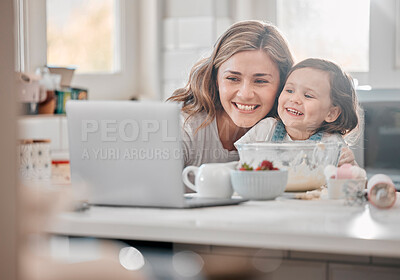 Buy stock photo Shot of a mother and daughter using a laptop in a kitchen