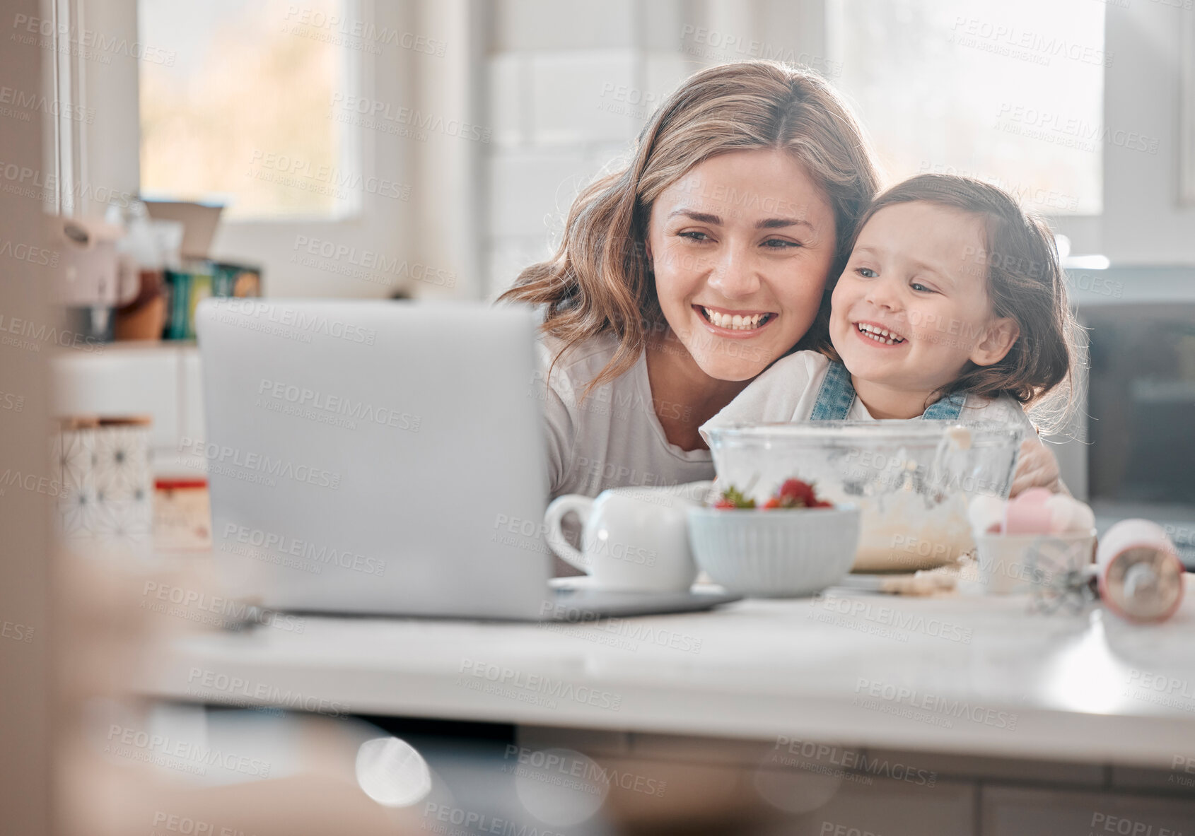 Buy stock photo Shot of a mother and daughter using a laptop in a kitchen