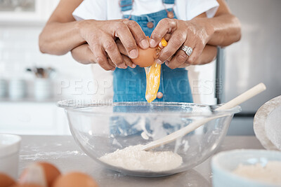 Buy stock photo Shot of a mature woman helping her granddaughter crack an egg into a bowl