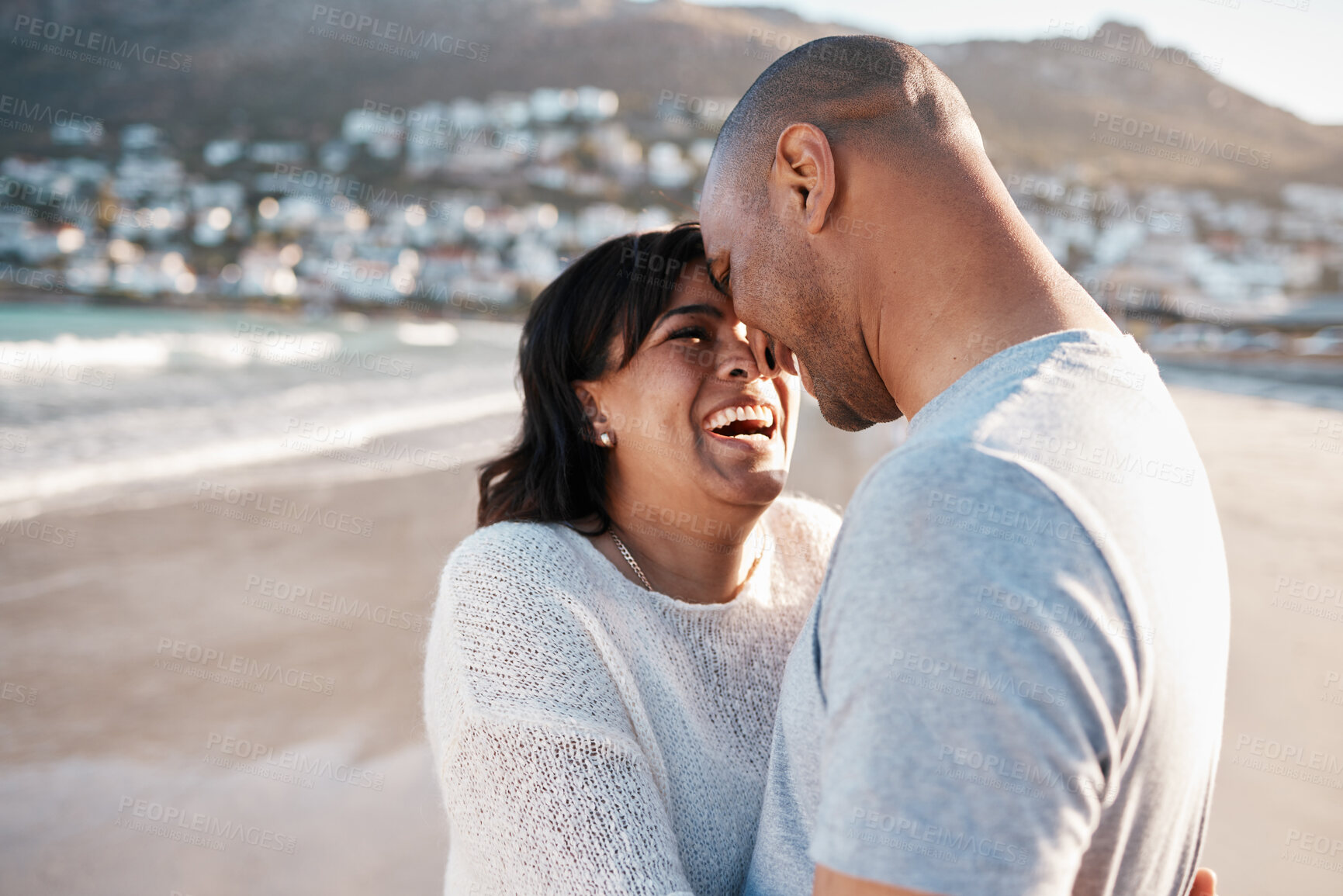 Buy stock photo Couple, hug and forehead for laughing on beach, romance and bonding for healthy marriage or trust. People, happiness and holiday in nature for relationship, embrace and funny conversation by ocean