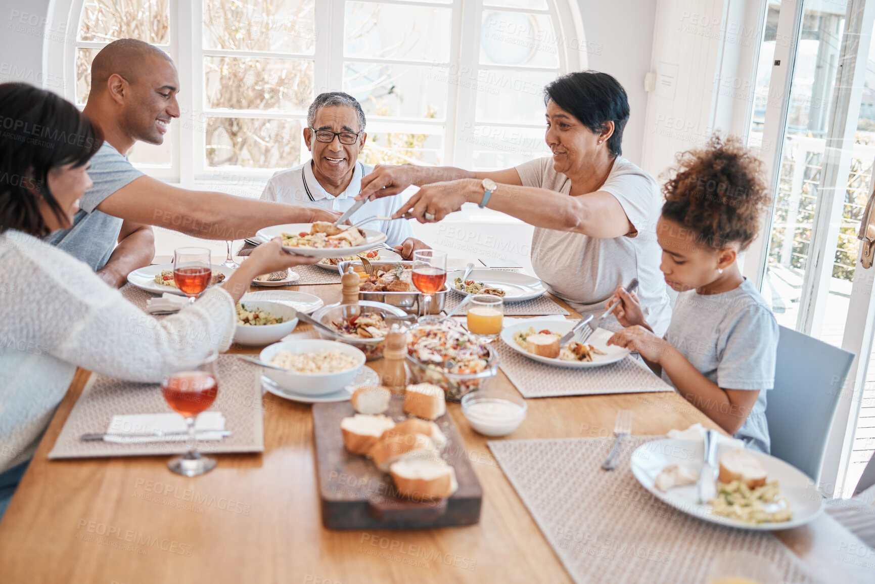 Buy stock photo Family, home and dining table for happy lunch, social gathering and brunch sharing meal or grandparents. People, love and woman serving or gourmet nutrition, apartment and together with healthy dish