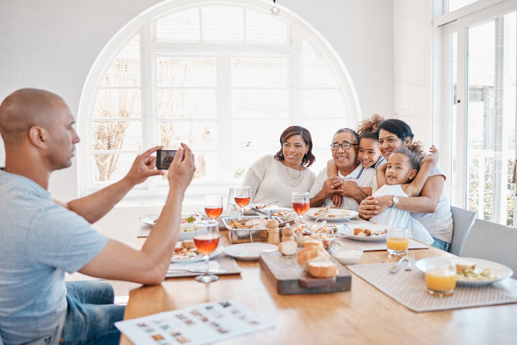 Buy stock photo Home, man and family with photography for dinner with smile for thanksgiving, gathering and reunion. People, generations and happy with food in table for memories, fun and social media with bonding