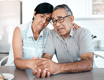 Buy stock photo Shot of a senior couple looking unhappy at home