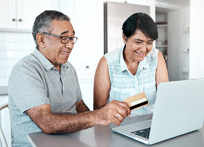 Buy stock photo Shot of a senior couple using a laptop and credit card at home