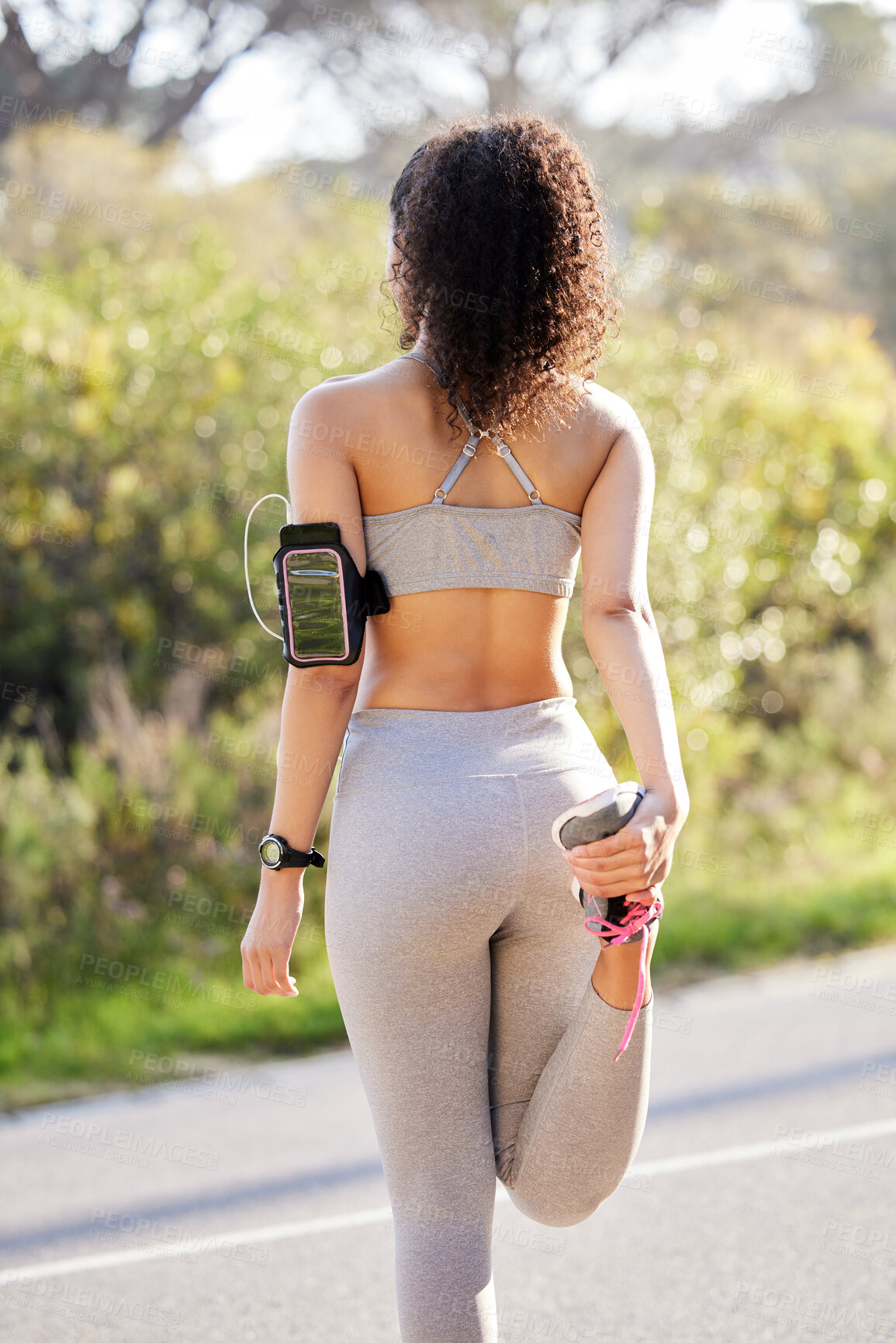 Buy stock photo Person, fitness and stretching legs outdoor for running, workout and cardio wellness in street with phone and music. Back of runner listening to audio and warm up for training, exercise or jogging