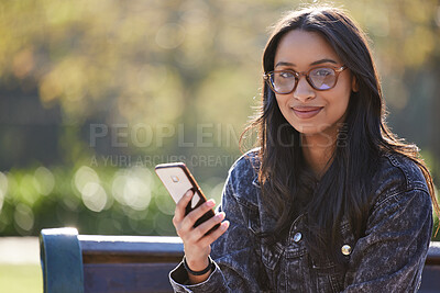 Buy stock photo Shot of a beautiful young student using her phone while sitting outside