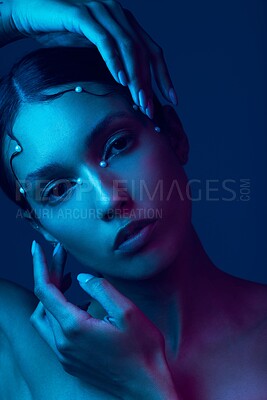 Buy stock photo Cropped portrait of an attractive young woman posing in studio against a blue background