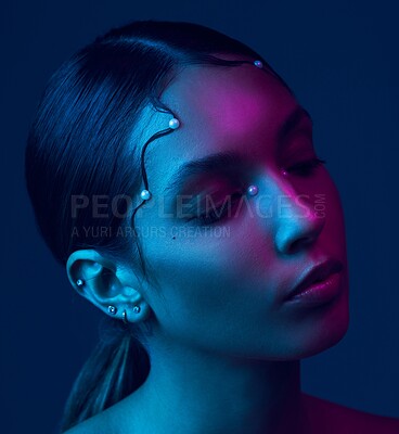 Buy stock photo Cropped shot of an attractive young woman posing in studio against a blue background