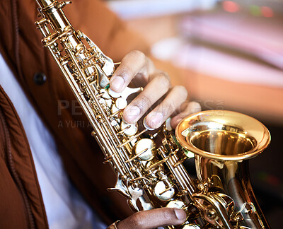 Buy stock photo Cropped shot of an unrecognizable male musician playing his saxophone at home