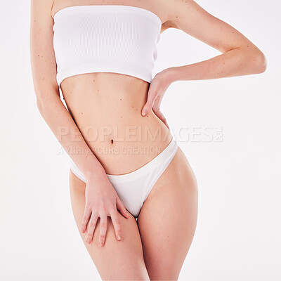 Buy stock photo Shot of a woman posing with her hands on her hips against a studio background