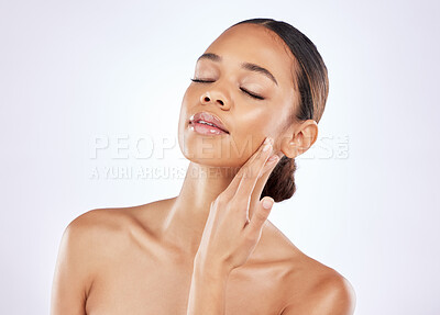 Buy stock photo Shot of a young woman posing against a studio background