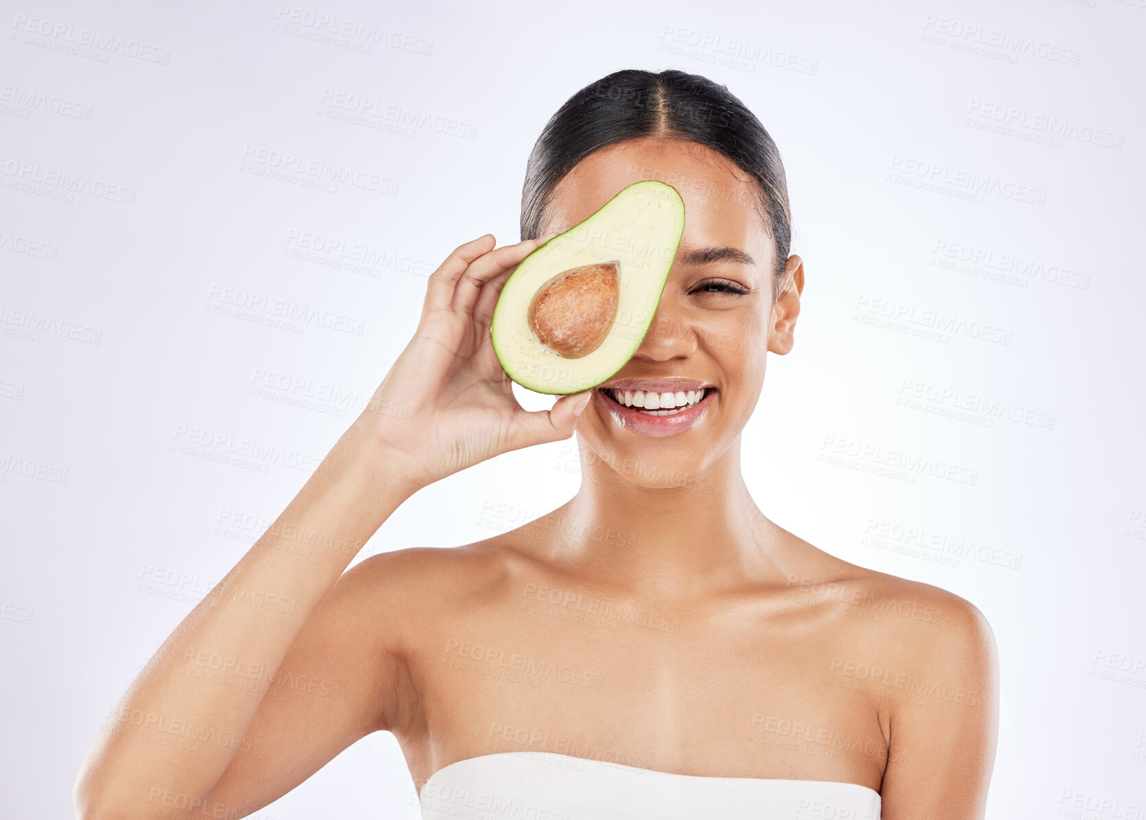 Buy stock photo Woman, white background and avocado with natural beauty for skincare with sustainability, fruit oil with cosmetics. Female person, studio and plant based for makeup, portrait with smile for wellness