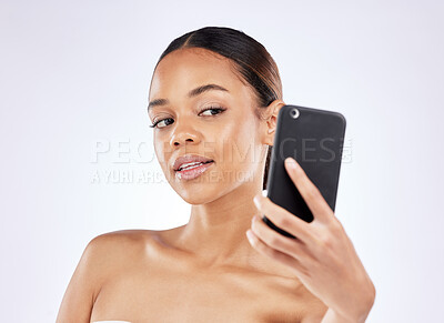 Buy stock photo Shot of a young woman talking selfies using a smartphone against a studio background