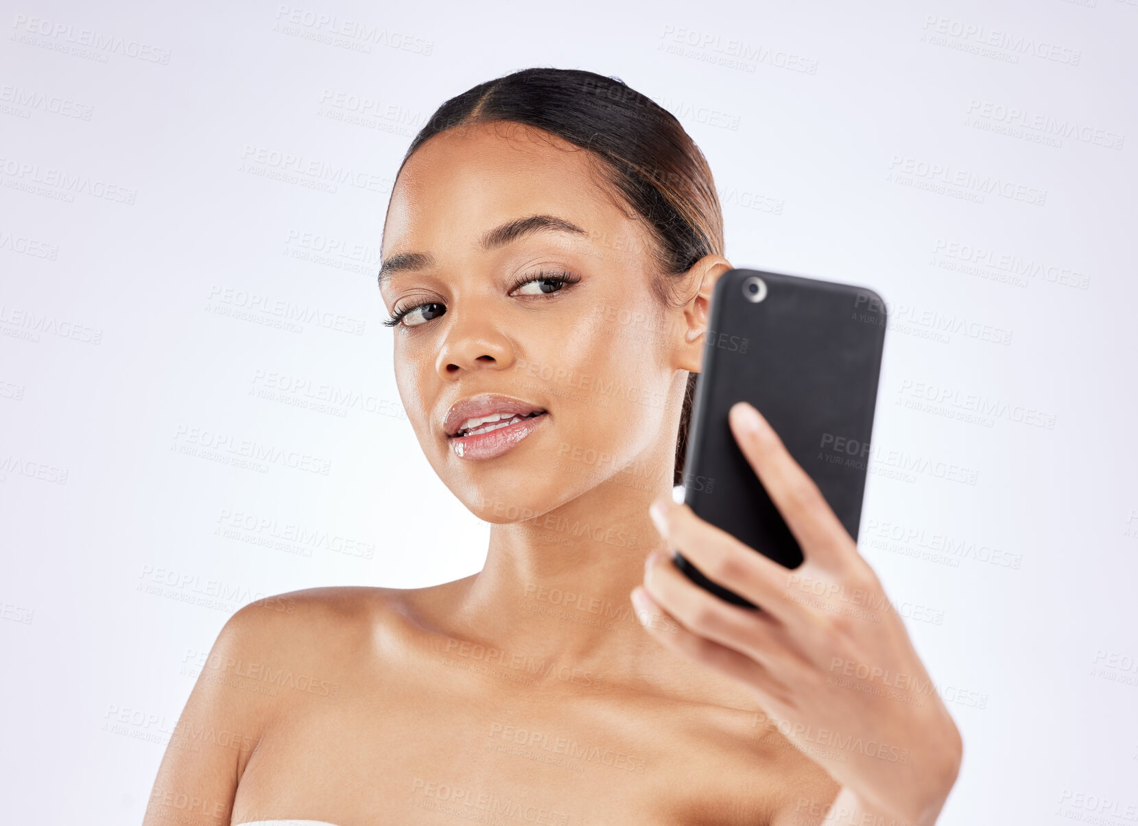 Buy stock photo Shot of a young woman talking selfies using a smartphone against a studio background