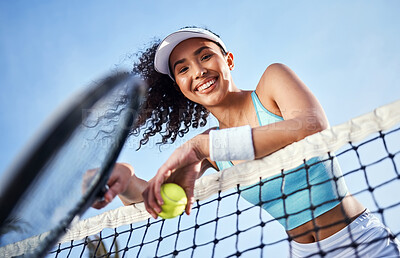 Buy stock photo Low angle shot of an attractive young woman standing alone and leaning on the tennis net during practice