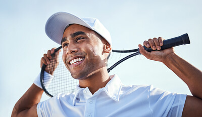 Buy stock photo Shot of a handsome young man standing and holding a tennis racket during practice